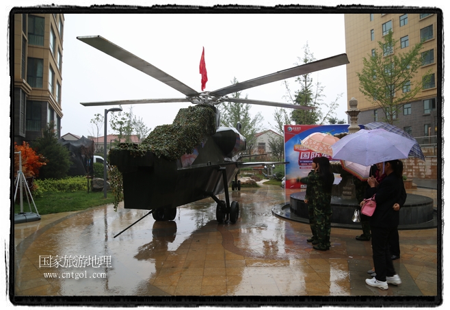 小區(qū)突然出現(xiàn)“飛機(jī)坦克”，其中殲15艦載戰(zhàn)斗機(jī)一架、99式主戰(zhàn)坦克一輛、武直-10武裝直升機(jī)一架，吸引了眾多市民雨中圍觀、合影。